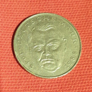 Könnte beinhalten: Eine Silbermünze mit dem Text "Deutsche Mark" und den Jahren "1949" und "1989" am Rand. Im Zentrum der Münze befindet sich ein Porträt eines Mannes.