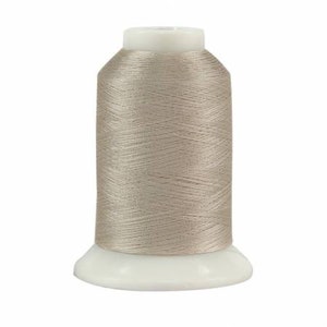 May include: A spool of beige thread on a white plastic bobbin.
