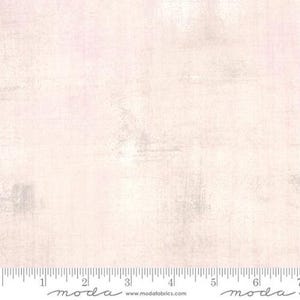 May include: A pale pink and white fabric with a subtle distressed texture. The fabric has a subtle sheen and a soft, slightly rough feel. The fabric is perfect for quilting, crafts, and home decor projects.