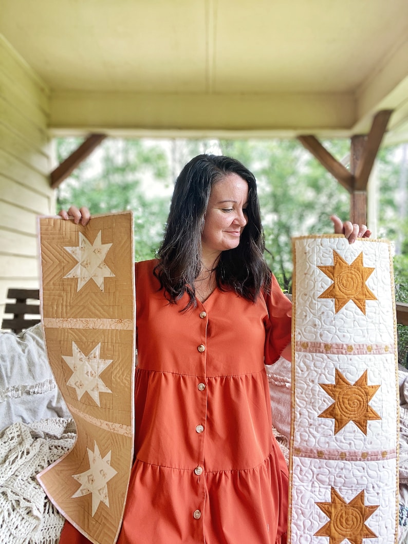 Puede incluir: Dos caminos de mesa acolchados hechos a mano con un dise&ntilde;o de estrella. Un camino de mesa es beige con estrellas blancas y el otro es blanco con estrellas doradas.