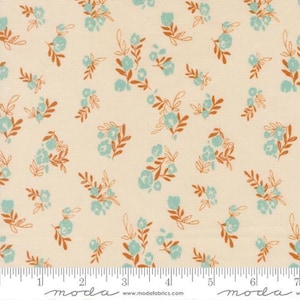 May include: Cream-colored fabric with a repeating floral pattern. Clusters of light blue flowers and rust-colored leaves are scattered across the surface. The fabric is measured in inches along the bottom edge.