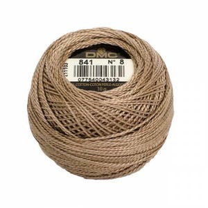 May include: A ball of DMC brand embroidery thread in a light brown color. The label shows the number 841, the number 8, a barcode, and the text "COTTON-COTON PERLE-ALGOD" and "10 g". The thread is tightly wound.