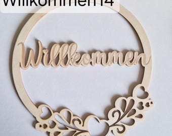 May include: A wooden welcome sign with the word "Willkommen" in cursive script. The sign is circular with a decorative floral and heart design at the bottom. The text "Willkommen14" is at the top left.