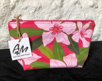 Medium, padded zipper pouch. digital print florals in pink and green on a bright, deep pink background