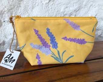 Medium, padded zipper pouch. Purple lavender flowers on a sunny yellow background