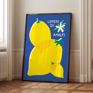 May include: A framed art print featuring a vibrant illustration of lemons against a deep blue background. The artwork includes the text "LIMONI DI AMALFI" and a white flower. The lemons are yellow with green stems, creating a striking contrast.