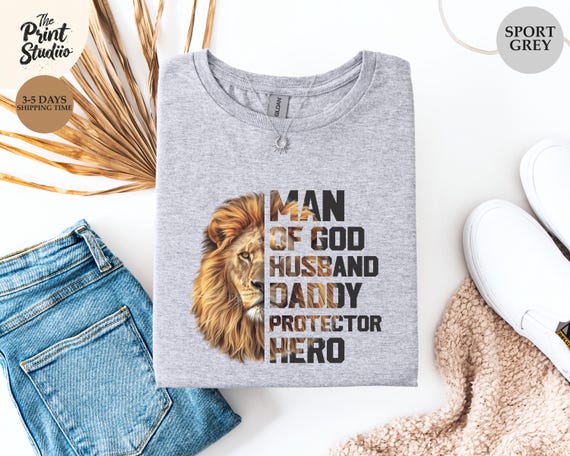 Man of God Husband Hero Shirt, Lion Graphic and Text Design, Christian Gift for Men, Strong Faith Tee, Bold Religious Fathers Day Shirt