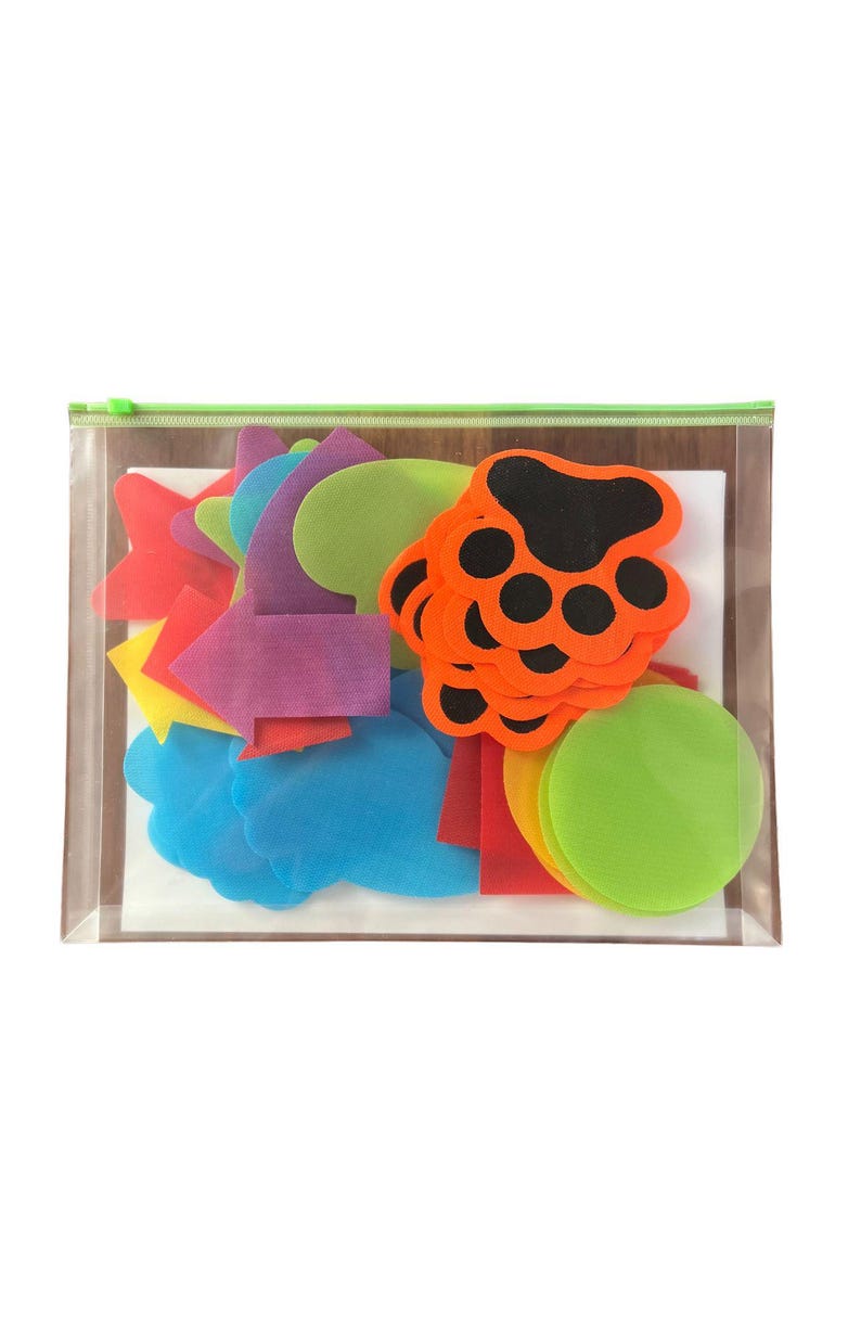 Peut inclure: Un sac en plastique transparent &agrave; fermeture &eacute;clair rempli de formes en feutre de diff&eacute;rentes couleurs, notamment des empreintes de pattes, des cercles, des fl&egrave;ches et des nuages.