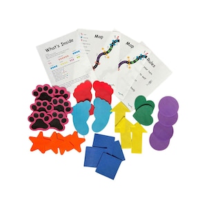Op de afbeelding: Een set kleurrijke vilt spelstukken voor een bordspel. De stukken omvatten poot afdrukken, voetafdrukken, sterren, vierkanten, pijlen, harten en cirkels. Het spel bevat instructies, een kaart en regels.