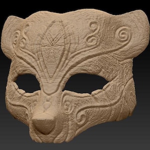 Puede incluir: Una máscara detallada y tallada intrincadamente con una cara de animal estilizada. La máscara está hecha de un material marrón claro y tiene una superficie texturizada. Los ojos son huecos y la nariz es prominente.