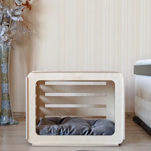 Interior view of the wooden dog crate displaying the spacious sleeping area with a removable gray dog bed cushion.
