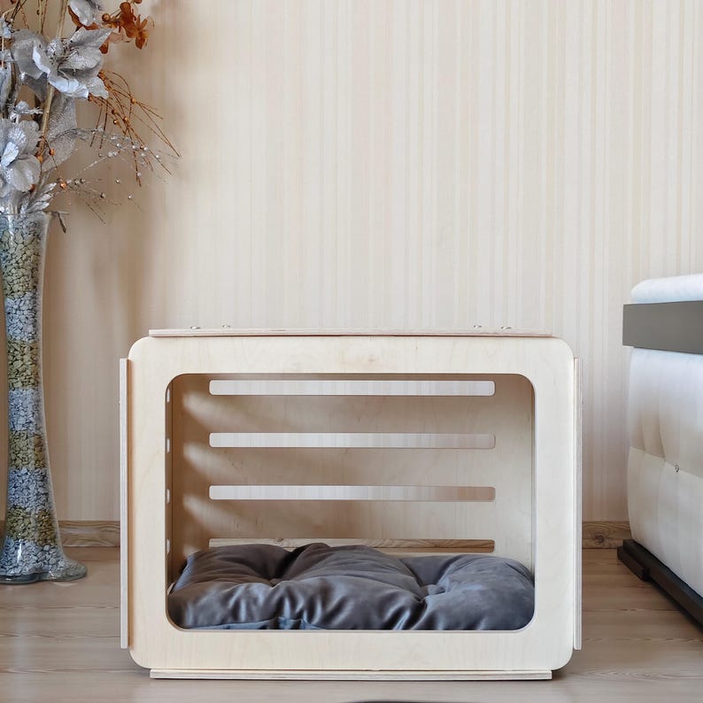 Interior view of the wooden dog crate displaying the spacious sleeping area with a removable gray dog bed cushion.