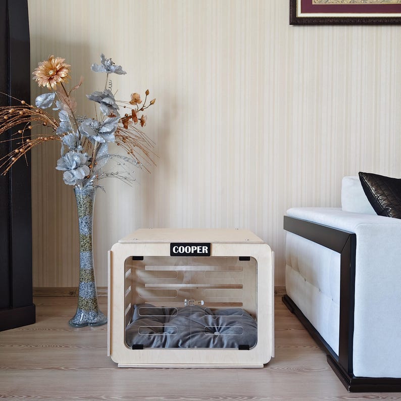 Interior of the indoor wooden dog house showing a spacious sleeping area with a removable gray dog bed cushion.