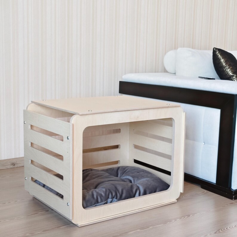 Front view of a birch plywood indoor dog crate furniture featuring an open acrylic door and ventilated wooden panels.