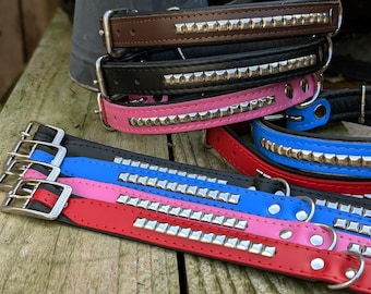 May include: A set of six dog collars in various colors, including black, brown, pink, red, and blue. Each collar features a row of silver studs.