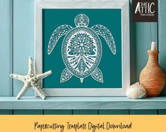 May include: A white papercut template of a sea turtle with a mandala design. The template is framed and displayed on a teal wall with a shelf below. The shelf has a starfish, a seashell, and a brown vase.