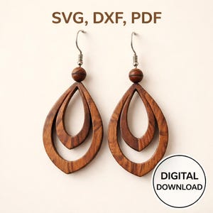 Könnte beinhalten: Ein Paar holzfarbene Tropfenohrringe mit geschichtetem Design. Die Ohrringe sind in einem satten Braunton gehalten und zeigen die Holzmaserung. Der Text "SVG, DXF, PDF" und "DIGITALER DOWNLOAD" ist im Bild enthalten.
