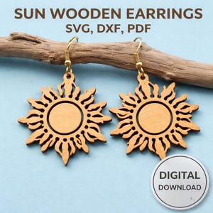 May include: Two wooden sun-shaped earrings with gold-colored hooks. The earrings are light brown and feature a circular center surrounded by stylized sun rays. The image includes the text "SUN WOODEN EARRINGS SVG, DXF, PDF" and a "DIGITAL DOWNLOAD" sticker.