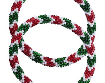 May include: Two circular beaded bracelets. The bracelets feature a pattern of red, green, and white beads. The design is reminiscent of festive decorations, with the beads tightly woven together.