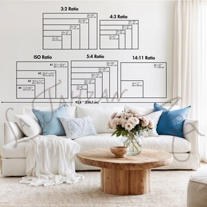 May include: A wall chart displaying various print aspect ratios including 3:2, 4:3, ISO, 5:4, and 14:11 with specific dimensions in inches and centimeters. The chart is positioned above a white sofa with blue pillows and a wooden coffee table.
