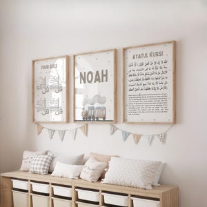 May include: Three framed wall prints featuring the Four Quls, the name Noah with a train illustration, and the Ayatul Kursi in Arabic and English text. The prints are displayed above a wooden storage unit with white bins and decorative bunting.