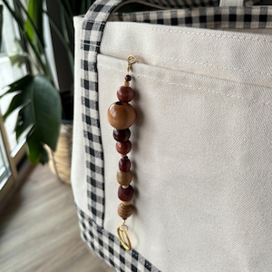 Llavero para bolso con cuentas de madera y detalles dorados, hecho a mano y personalizable en estilo y longitud, perfecto para regalar.