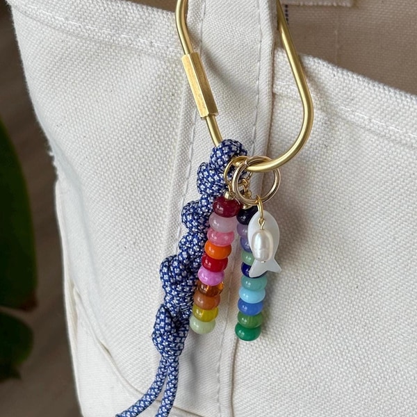 Llaveros con dijes para bolsos, cuentas de vidrio y cerámica, detalles dorados y detalles de paracord. Hechos a mano y personalizables. Regalos con diseños coloridos.