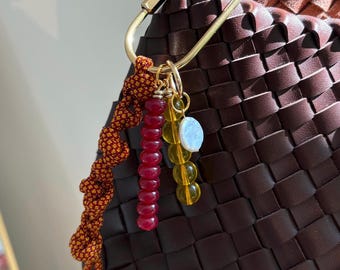 Llaveros con dijes para bolsos, cuentas de vidrio y dijes de perla, detalles dorados y detalles de paracord. Hechos a mano y personalizables. Perfectos para regalar en el bolso.