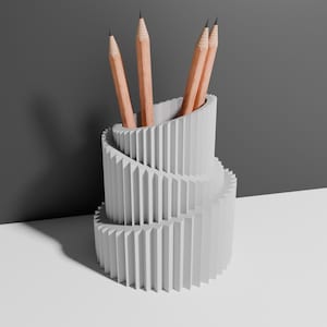 May include: White ceramic pencil holder with a spiral design. Four wooden pencils are placed inside the holder.