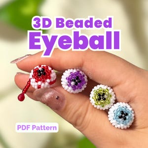 Puede incluir: Cuatro globos oculares pequeños hechos con cuentas en 3D de colores rojo, morado, verde y azul, cada uno con base blanca y pupila negra. El globo rojo incluye una lágrima de cuentas roja colgante. El texto 3D Beaded Eyeball y PDF Pattern es visible.