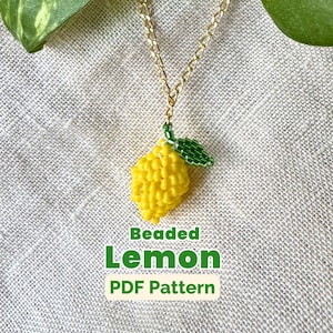 Peut inclure: Un collier pendentif en forme de citron perlé avec une chaîne dorée. Le charme du citron est jaune avec une feuille perlée verte. Le texte "Beaded Lemon PDF Pattern" est affiché en dessous.
