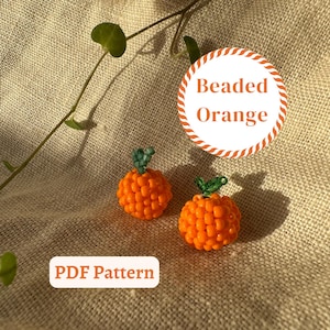 Peut inclure: Deux ornements de fruits orange perlés avec des tiges vertes. Les oranges sont faites de petites perles rondes orange. L'image comprend également un graphique circulaire qui dit "Beaded Orange" et un graphique rectangulaire qui dit "PDF Pattern".