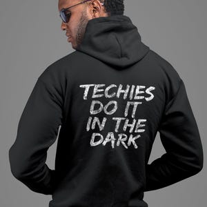 Può includere: Felpa con cappuccio nera con il testo "Techies Do It In The Dark" stampato in bianco sul retro.