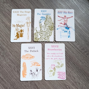 Może przedstawiać: Pięć kart z ilustracjami i tekstem. Karty są białe z czarnymi obramowaniami. Tekst na kartach jest czarny i brązowy. Ilustracje są czarne, brązowe, niebieskie i zielone. Karty są ponumerowane XXIII, XXIV, XXV, XXVI i XXVII. Tekst na kartach brzmi: XXIII Magik sceniczny, To magia!, XXIV Hazardzista, XXV Wyścig, XXVI Potluck, XXVII Truskawki, "Po prostu nie można powiedzieć, gdzie truskawki i galaretka się zaczynają!"