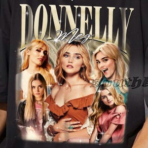 May include: Black t-shirt featuring a vintage-style graphic of the name "DONNELLY" above a photo collage of five women. The shirt has short sleeves and a relaxed fit, suitable for casual wear.