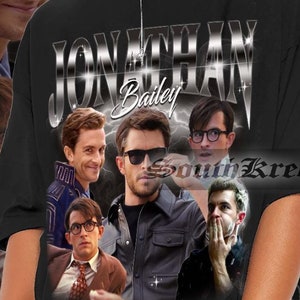 May include: A black t-shirt with a silver graphic print of the text "JONATHAN Bailey" and several images of men. The shirt is being worn by a person with long black hair and sunglasses.