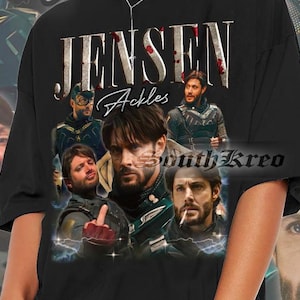 May include: Black t-shirt with a collage of images of Jensen Ackles, including a close-up of his face, a photo of him in a costume, and a photo of him with a cigarette. The text "Jensen Ackles" is printed in large, white letters across the top of the shirt.