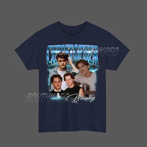 Peut inclure: T-shirt bleu marine avec un graphisme de style vintage. Le motif pr&eacute;sente le nom "Christopher" en bleu avec un effet d'&eacute;clair, ainsi que quatre images de jeunes hommes et le nom "Briney".