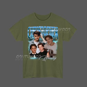 Peut inclure: T-shirt vert olive avec un graphisme de style vintage. Le motif pr&eacute;sente le nom "Christopher" en bleu, superpos&eacute; &agrave; un collage de quatre jeunes hommes. Le texte "Southwest Briney" est &eacute;galement visible.