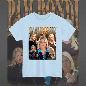 May include: Light blue t-shirt with a graphic print of Pam Bondi, a former Florida Attorney General. The graphic features multiple images of Bondi in different poses, with the text "PAM BONDI" in gold letters.