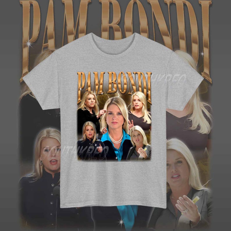 May include: A grey t-shirt with a graphic print of Pam Bondi, a former Florida Attorney General. The graphic features a collage of images of Bondi, including a close-up of her face and a photo of her with other people. The text "PAM BONDI" is printed in gold letters on the shirt.