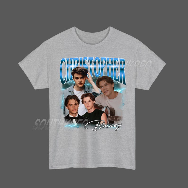 Peut inclure: Un t-shirt gris clair avec un imprim&eacute; de quatre jeunes hommes et le nom "Christopher" en bleu. Le mot "Briney" est &eacute;crit en cursive en dessous des images. Le t-shirt a des manches courtes.