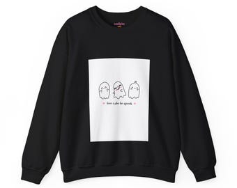 May include: A black long-sleeve sweatshirt featuring a central white rectangular graphic. The graphic displays three small, hand-drawn style ghosts with smiling faces and the text "too cute to spook" flanked by two small pink hearts.