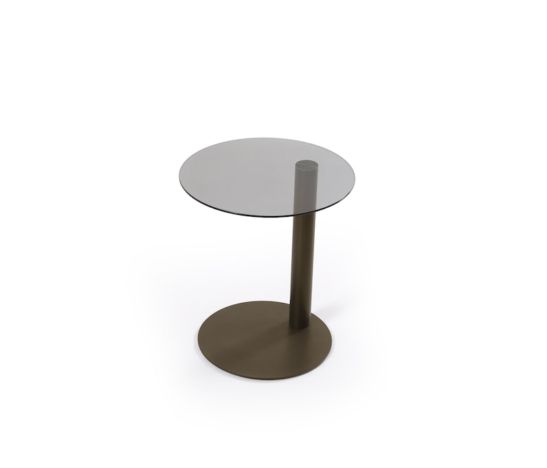 Op de afbeelding: Een bijzettafel met een rond, halfdoorzichtig grijs glazen blad, ondersteund door een enkele, dikke, cilindrische kolom van donkerbruin metaal die verbonden is met een platte, ronde voet van donkerbruin metaal voor een gebalanceerd meubel.