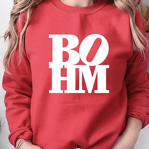 May include: Red sweatshirt with white text that reads "BOHM".