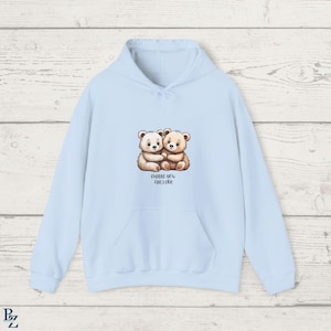 May include: Light blue hoodie with a graphic of two brown teddy bears hugging and the text "Cuddle Now,  Hug Later".