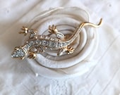 Vintage rhinestone gecko with green eyes in silvertone.