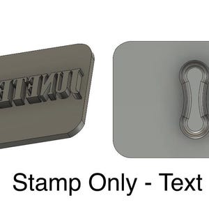 May include: A gray rectangular stamp with the word "UNITEENTH" embossed on it. The stamp is next to a gray rectangular cutout with a keyhole shape.