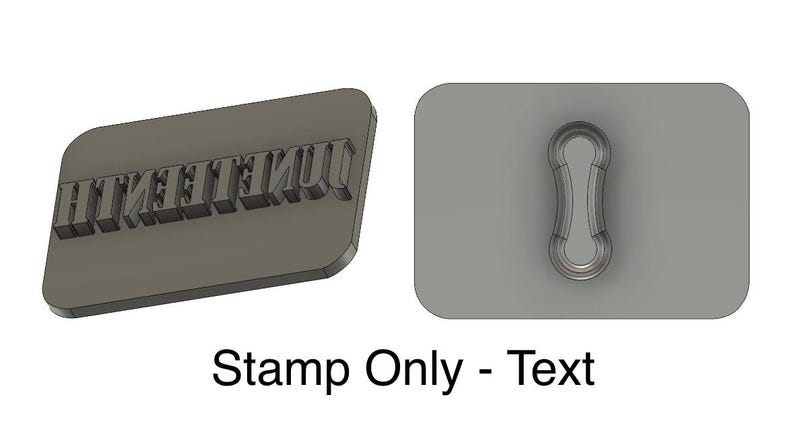 May include: A gray rectangular stamp with the word "UNITEENTH" embossed on it. The stamp is next to a gray rectangular cutout with a keyhole shape.