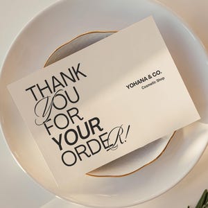 Puede incluir: Una tarjeta de agradecimiento blanca con texto negro que dice "¡Gracias por tu pedido!" y el nombre de la empresa "YOHANA & CO. Tienda de cosméticos".